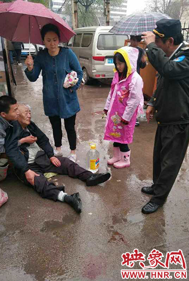 女孩為倒地老人撐傘。