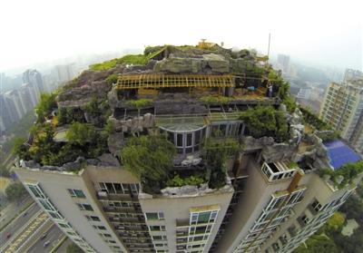 　　昨日，身穿橘黃色馬甲的工作人員在人濟山莊樓頂拆除違章建筑。新京報記者 吳江 攝