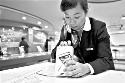 11月6日，北京移動西直門營業(yè)廳的工作人員在為顧客購買的4G手機登記。新華社發(fā)