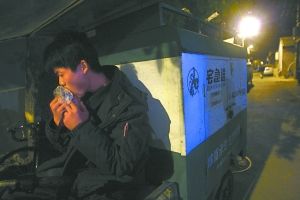 快遞哥抽空吃兩口東西。記者 李剛 攝