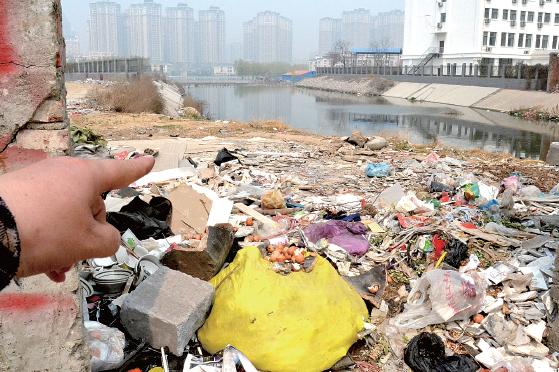 金水河長江路橋下河水發(fā)臭，水邊堆放眾多垃圾