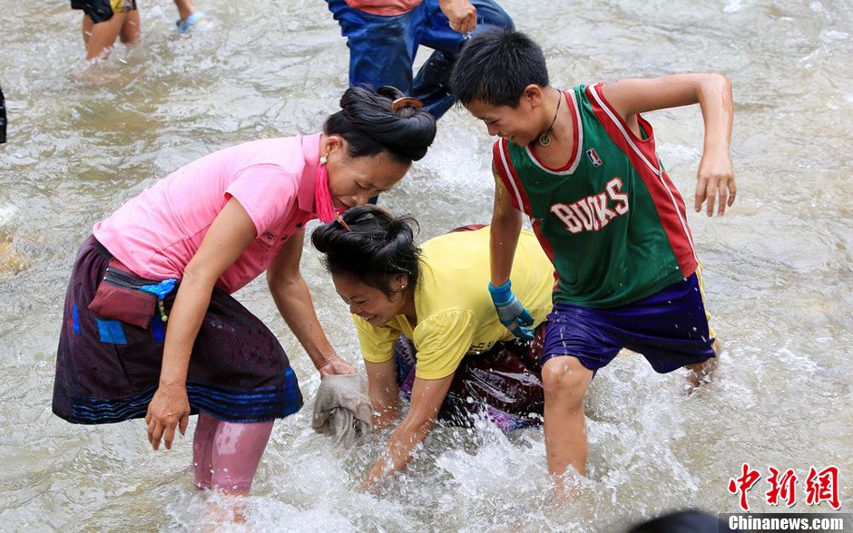 7月9日，村民在小河里摸魚搶魚。譚凱興 攝