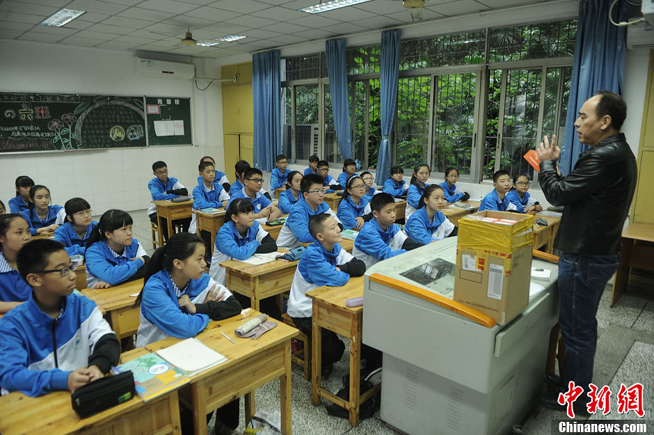 圖為老師正在向同學(xué)們講解用非智能手機(jī)對(duì)他們的好處。