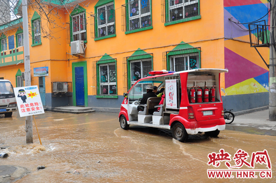 巡防隊員將巡消車開到對面，將上學(xué)的小朋友一個一個接上車，送出家屬院