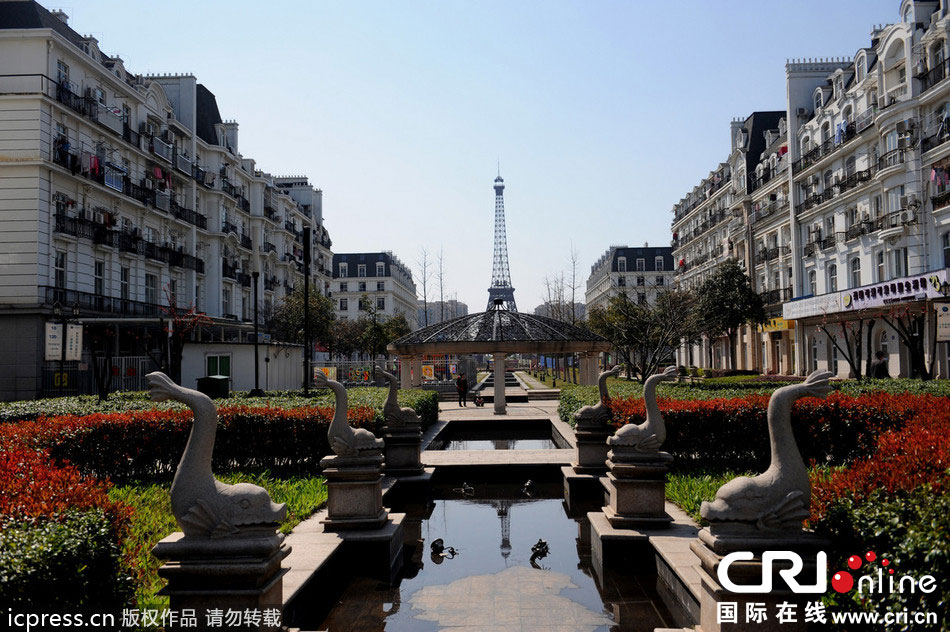 　2014年3月21日，杭州天都城，農(nóng)民在山寨埃菲爾鐵塔下耕作。圖片來源：東方IC