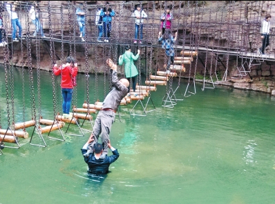 中年男游客正踩著景區(qū)安全員郭小明的肩膀過(guò)河。網(wǎng)友“@我的小名叫張孩”供圖