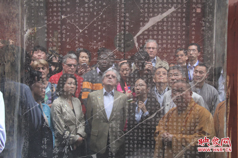 在一塊石碑前，少林寺方丈正在講解