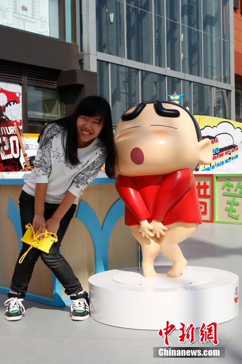 4月22日，游客與蠟筆小新合影。“蠟筆小新25周年紀念特展”日前在北京開展，吸引了不少市民游客。