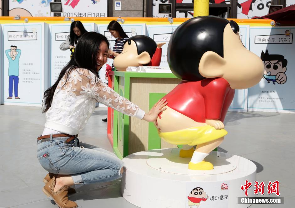 4月22日，游客與蠟筆小新合影。“蠟筆小新25周年紀念特展”日前在北京開展，吸引了不少市民游客。