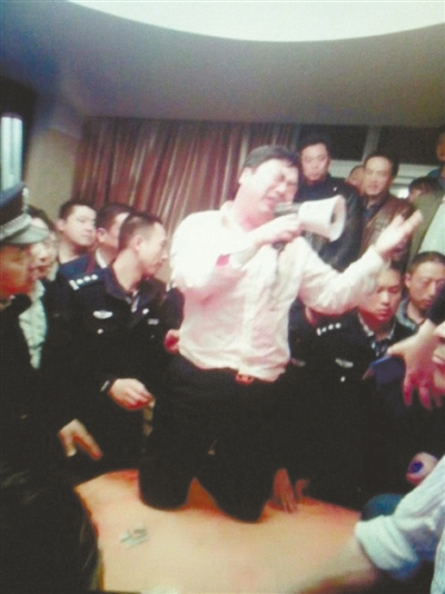 　4月19日，泰州市濱江工業(yè)園區(qū)管委會(huì)招待中心，一男子跪在酒桌上喊話求饒。李根 攝