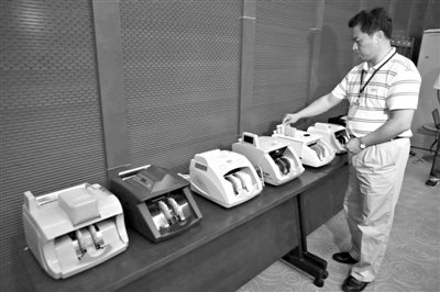 昨日，央行工作人員用各種驗鈔機對C1F9假幣進行測試，機器均能及時作出異常報警反應。新京報記者 浦