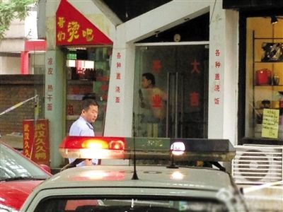 闖入面館的持刀男子與趕來的民警隔著玻璃門對(duì)峙，后店內(nèi)一名女童被其劫持。網(wǎng)友供圖
