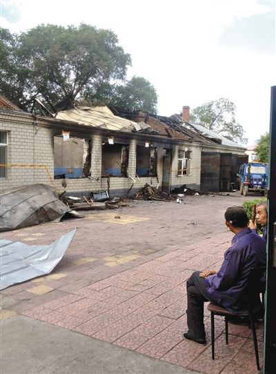 7月27日，海倫聯(lián)合敬老院內(nèi)，幾名老人看著對面被燒毀的特護病房。新京報記者 涂重航 攝