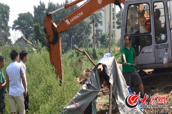 陳寶成手持自制刀斧守在挖掘機(jī)旁阻止便衣民警靠前。駕駛室內(nèi)，張朋珂正向受害人郭曉剛身上澆汽油。（視頻截圖）