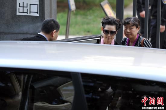 圖為宣判結(jié)束后夢鴿面無表情走出海淀法院，乘車離開。