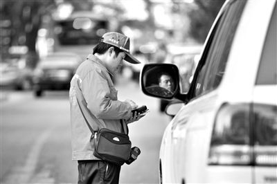 10月15日，朝陽區(qū)東大橋路，停車管理員從腰間掏出一個(gè)專用POS機(jī)，正在錄入停車信息。新京報(bào)記者 周崗峰 攝