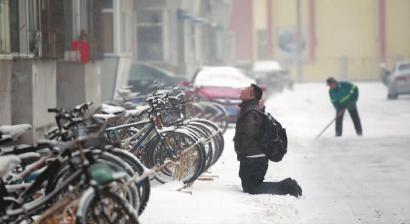 小伙子跪在樓前，一直抬頭看著樓上。 孫立國(guó)/攝