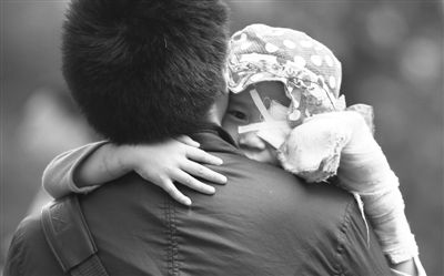 昨日，北京同仁醫(yī)院，被砍傷的彤彤趴在舅舅的肩上。他們剛剛掛完號(hào)，正準(zhǔn)備回旅館。新京報(bào)記者 尹亞飛 攝