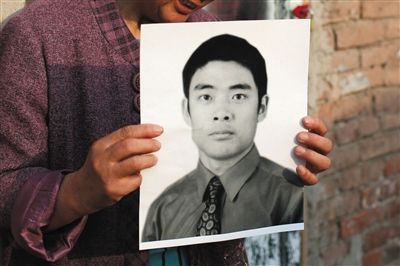 5月19日，朝陽(yáng)北路，母親捧著張東文的遺像。新京報(bào)記者 侯少卿 攝