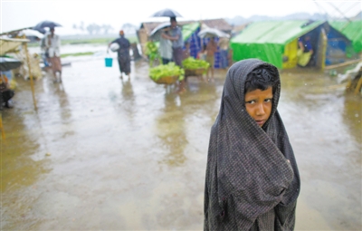 5月14日，緬甸若開(kāi)邦實(shí)兌難民營(yíng)，羅興亞族難民在雨中行走。熱帶風(fēng)暴“馬哈森”即將登陸緬甸，這里的難民開(kāi)始乘船撤離。