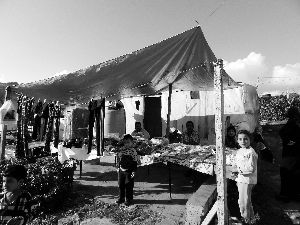 黎巴嫩一敘利亞難民營(yíng)，難民支起攤鋪賣衣服掙錢。