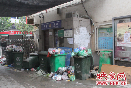 七個裝滿垃圾的大桶已經(jīng)將進出小區(qū)的路堵了一半