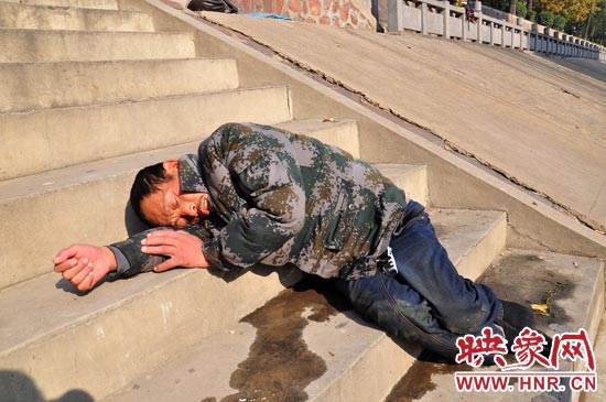 這名男子的衣服以及褲子全濕透了，水從衣褲里流出來，嘴里散發(fā)著濃烈的酒氣。