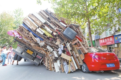 紅色小轎車被砸，卡在路邊動彈不得。