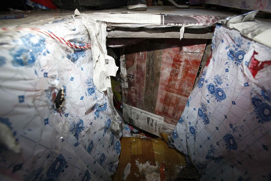 陳小龍?jiān)诔鲎馕萃?，自行又圍起一堵圍墻，安裝了一個(gè)門。圍墻上都是豎起的鐵釘，外面堆著土，鄰居猜是從地底挖出來的。洞口就在床邊，0.5米見方，深約1.5米。洞口表面一塊紙板掩蓋，打開紙板跳入洞底，是一扇小木門，木門外有插銷，可以從外面鎖上。