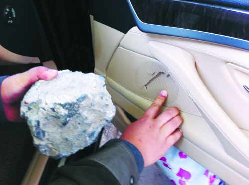 “飛”進(jìn)寶馬車內(nèi)的大石塊,將寶馬車的車門內(nèi)飾板砸爛。