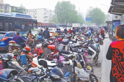 省人民醫(yī)院北門，路邊的公交站牌處停滿非機動車，上、下客只能在快車道上。