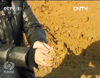 麻剛沙系麻剛石粉碎而成。記者找到一塊麻剛石，一捏就碎成粉末，硬度非常差。央視截圖