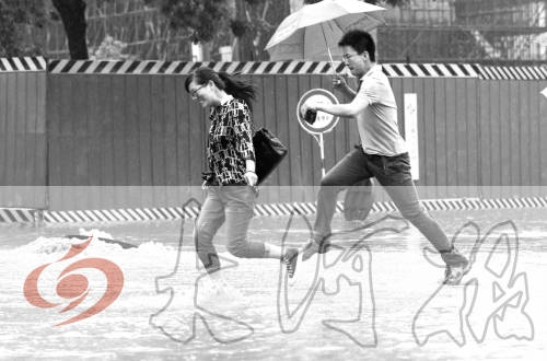 鄭州經(jīng)三路與北環(huán)交叉口處，積水較深，行人們不得不“練輕功”。 記者 白周峰 攝影