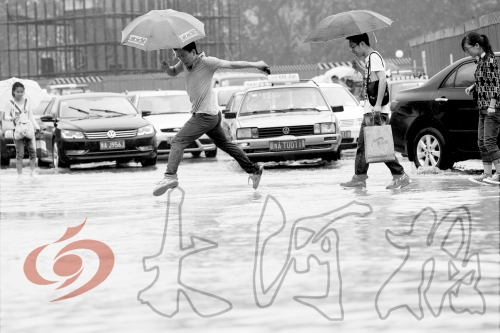 鄭州經(jīng)三路與北環(huán)交叉口處，積水較深，行人們不得不“練輕功”。 記者 白周峰 攝影