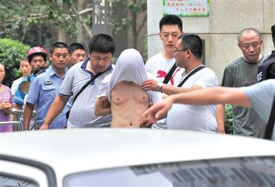 昨日，成都警方抓捕時與毒犯發(fā)生槍戰(zhàn)。一名男犯罪嫌疑人被警方押出。