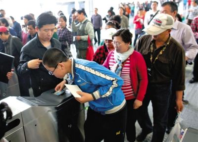 去年5月5日，14號線園博園站，乘客刷卡出地鐵。北京公交地鐵將實行計程票制，多乘坐多付費。