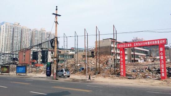 015年5月31日，在社區(qū)干部的帶頭拆遷下，親賢社區(qū)的“城中村改造”拉開帷幕。由于前期“清產核資”及補償標準等因素，拆遷改造工作推進并不順利。圖為位于體育西路東側集體所有的商鋪率先被拆遷完畢，用于遮擋的圍擋正在施工中。（拍攝：2015年9月16日）