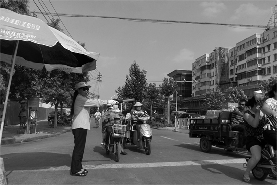 昨日，開封市區(qū)一名協(xié)管員在指揮群眾過(guò)馬路