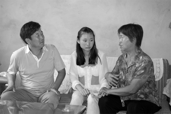 “商丘最美女兒”李丹（中）捐骨髓救母，愛心人士（左）送來1萬元愛心款