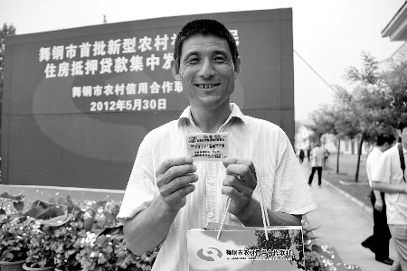 領(lǐng)到貸款，農(nóng)民開(kāi)心地笑了。