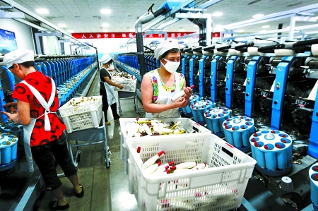 6月6日，舞鋼市鑫海紡織有限公司員工正在新建成的紡紗車間生產(chǎn)。