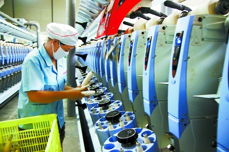 7月3日，在鄧州市永泰棉紡有限公司電腦控制全自動紡紗車間，紡織工人正在生產(chǎn)棉紗。