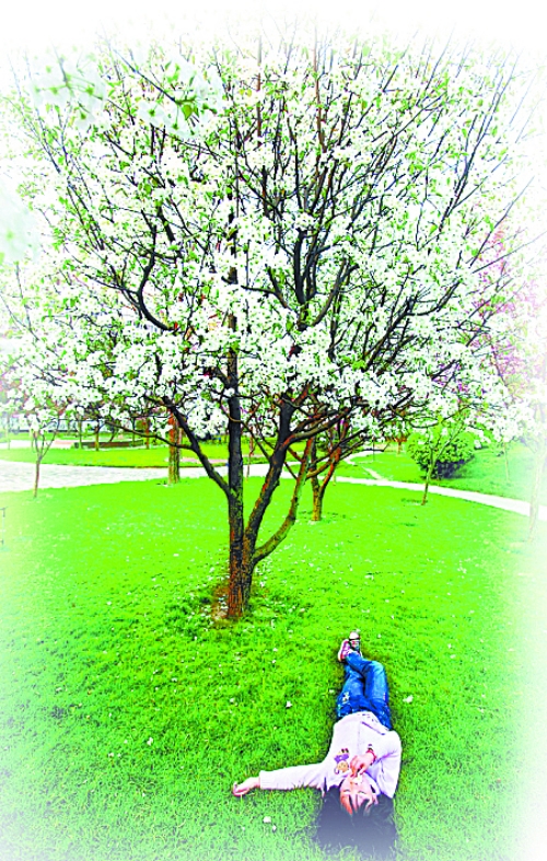 　孩子愜意地躺在社區(qū)內(nèi)的草坪上。