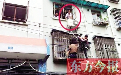 施救現(xiàn)場，劉鵬（圈內(nèi)）先用繩子捆住老太確保安全 勞動報記者 郭娜 供圖