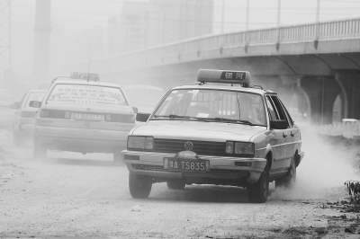 施工的道路上，車輛通過塵土飛揚。
