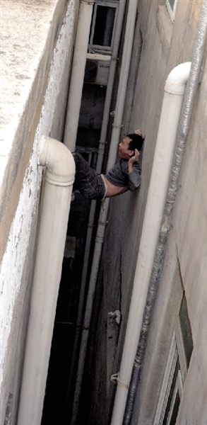 就在民警緊急施救時，他從兩樓之間摔下。