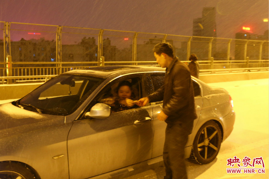 “推車人”幫助一輛車上坡后，收取“勞務(wù)費(fèi)”。