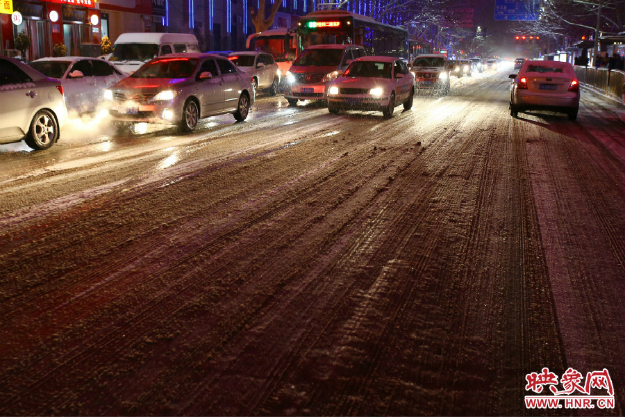 夜晚的雪路給出行的人們增加了困難。