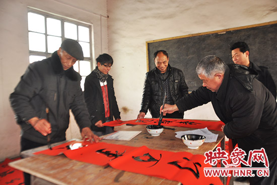 鞏義市魯莊鎮(zhèn)農(nóng)民書法愛好者正在寫春聯(lián)。