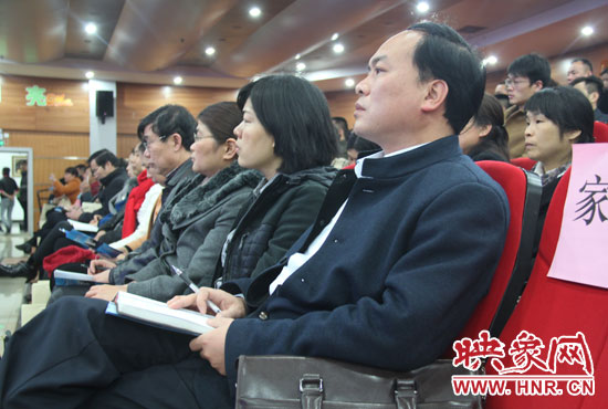 認(rèn)真聽取招生政策的學(xué)生家長。